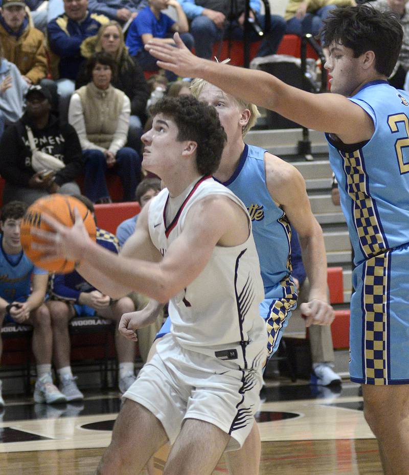 Woodland’s Brezdyn Simons sets to shoot as Marquette’s Connor Baker tries to block in the 2nd period Friday at Woodland.