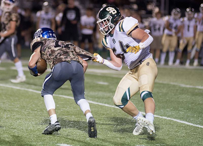 St. Bede’s Benjamin Burke grabs a hold of Newman QB Carter Rude’s jersey Friday, Sept. 16, 2022.