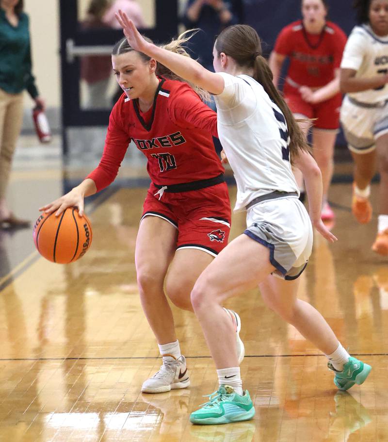 Yorkville's Bella Phillips pushes the ball ahead against Oswego East's Maggie Lewandowski during their game Tuesday, Feb. 11, 2025, at Oswego East High School.