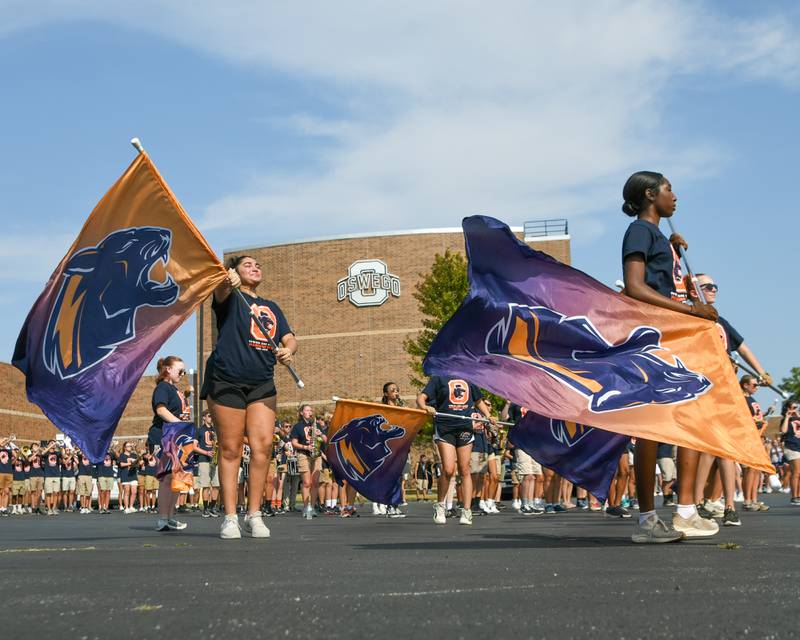 Oswego High School color guard warms up with their parade routine before they start the homecoming parade on Sunday Sept. 15, 2024, that started and ended at Oswego High School.