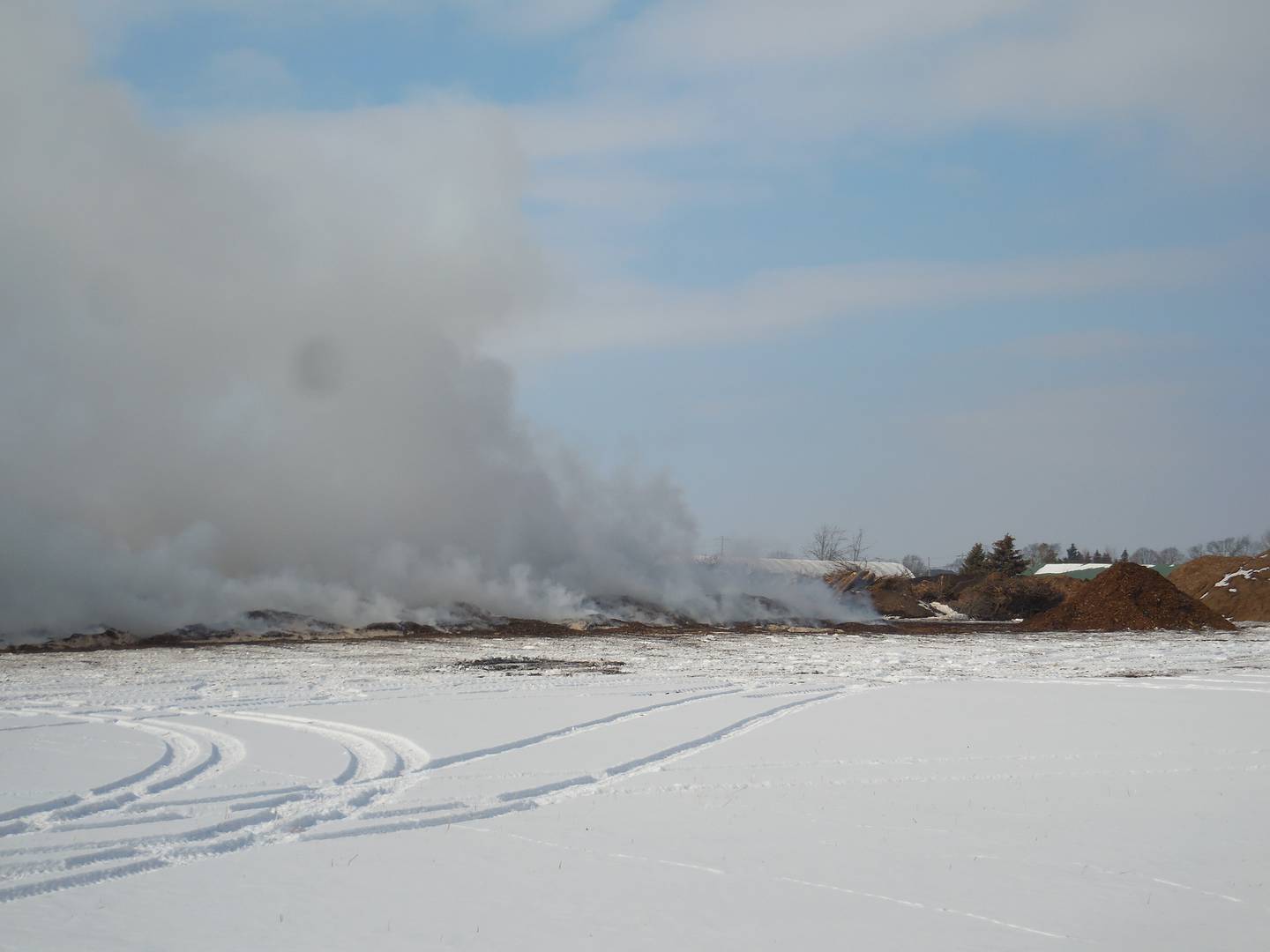 Piles of mulch that caught fire Friday were still smoldering three days later.