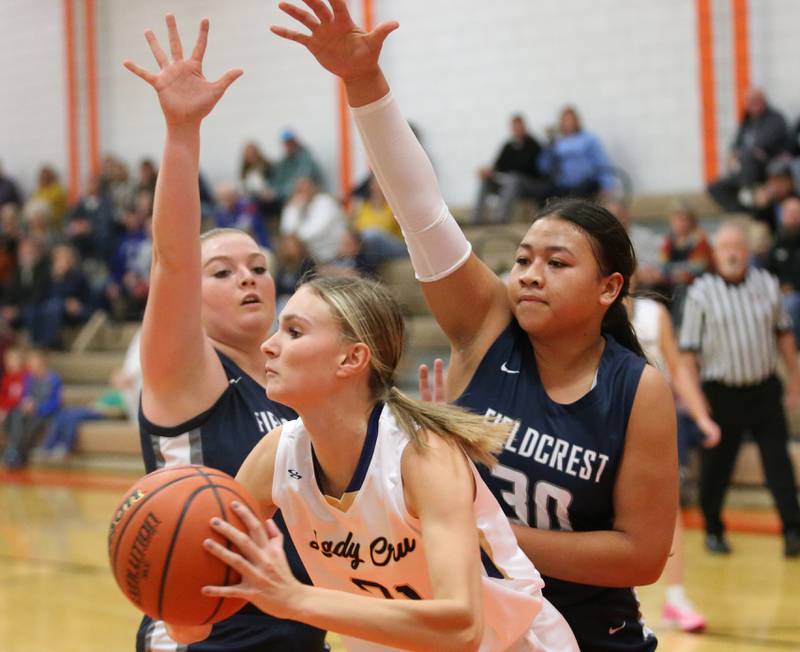 Marquette's Avery Durdan looks to pass the ball into the lane as she is guarded heavily by Fieldcrest's riley Burton and teammate Aliah Celis during the Integrated Seed Lady falcon Basketball Classic tournament on Monday, Nov. 13, 2023 at Flanagan High School.