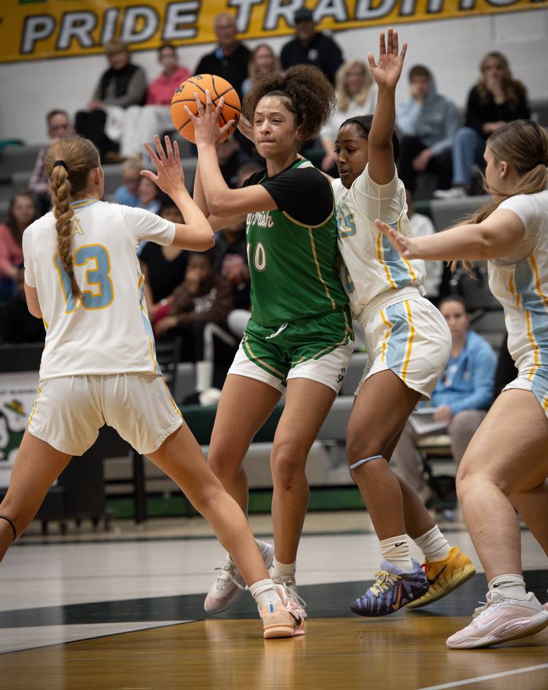 Bishop McNamara's Trinitee Thompson, center, looks to pass while being guarded by Joliet Catholic's Abby Dulinsky, left, and Gabrielle Gavin, right, during the Class 2A Regional Championship on Thursday, Feb. 19, 2026.