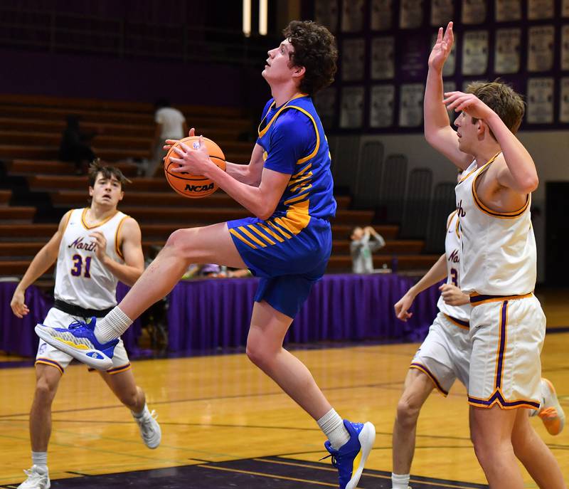 Lyons Township’s Owen Carroll  goes to the hoop between three Downers Grove North defenders during a game on January 15, 2026 at Downers Grove North High School in Downers Grove .