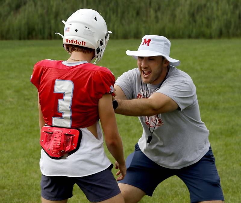 Marian Central Head Football Liam Kirwan explains to Max Kinney how he wants him to play defense during football practice on Tuesday, August 19, 2025, at Marian Central  High School in Woodstock.