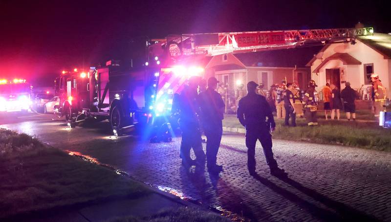Firefighters gather around a home in the 500 block of West Erie street for a structure fire on Monday, May 4, 2026 in Spring Valley. The fire happened shortly before 10:45p.m. A Mutual Aid Box Alarm System (MABAS) call was dispatched for additional fire departments from Eastern Bureau County, Peru, Utica, Oglesby and La Salle.