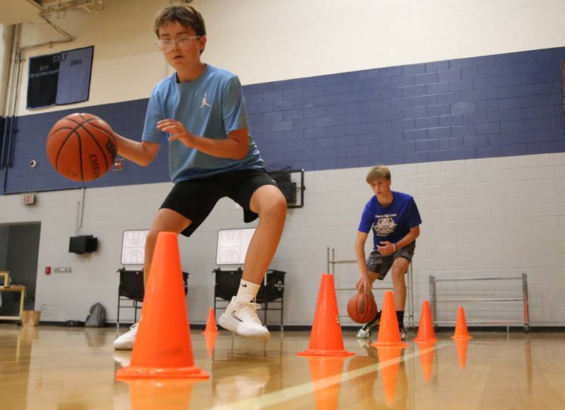 Kellen Bogner of Henry and Carson Sommers of Princeton work on dribbling around cones during the Fellowship of Christian Athletes Basketball Camp on Tuesday, July 8, 2025 at Bureau Valley High School.