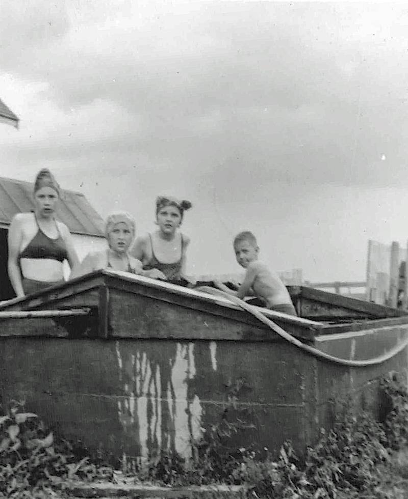 With no swimming pools available, many farm kids made do with cooling dips in their farm’s livestock tanks during summers in the 1940s, 1950s, and 1960s.  (From left) Eileen and Elaine Matile and Louise and Herbie Norris cool off in the Matiles’ stock tank.