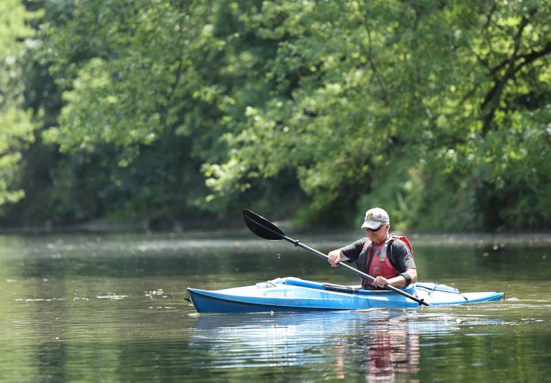 Greg Romaneck picks things up as he kayaks Thursday, Aug. 10, 2023, in the Kishwaukee River near the Knute Olson, Jr. Forest Preserve in Kingston. Romaneck has been making regular visits to pick up trash as he paddles the river and been an advocate for keeping the river and its surroundings free of pollution.