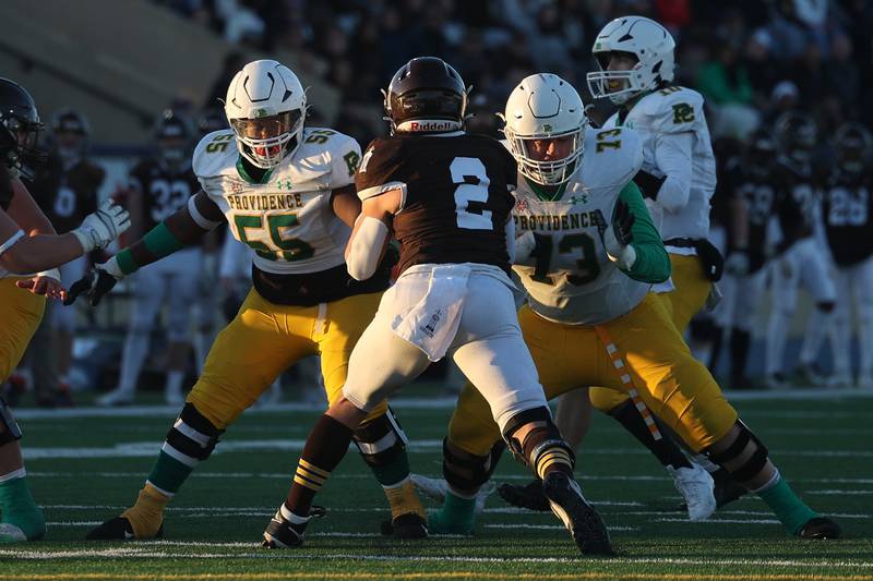Providence’s Koda Miller, 55, and James Barry, 73, provide protection for Leo Slepski against Joliet Catholic in the Class 5A semifinal on Saturday, Nov. 18, 2023, in Joliet.