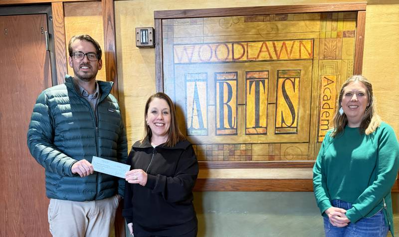 Adam Czamanske (left) and Anne-Marie Williams (right) of Prairie Brome Solar present a check to Woodlawn Arts Academy Executive Director Christy Zepezauer. The grant will be used to support the Academy’s partner theater program with Dixon Public Schools.