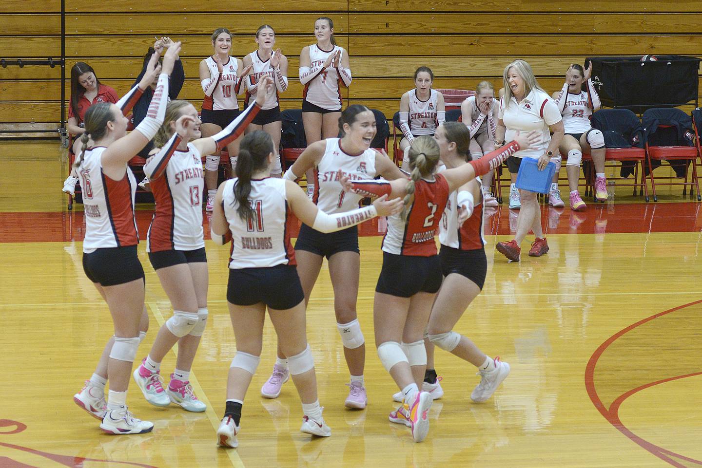 The Streator Lady Bulldogs celebrate their win in the 1st set Tuesday against Lisle at Streator.