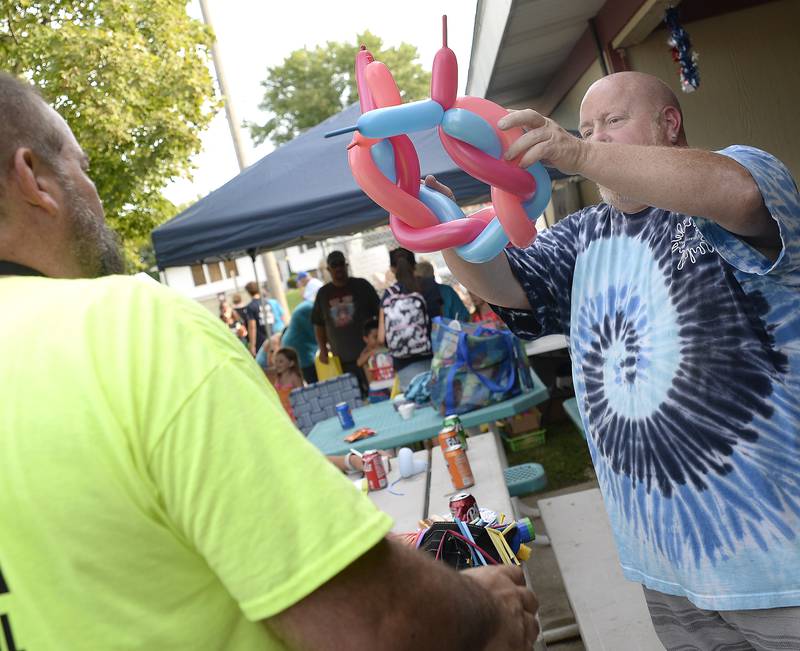 Balloon Artist Jim Martin hands out a creative hat he made Tuesday, Aug. 1, 2023, at the Marseilles Pool during National Night Out.