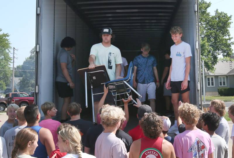 Students from La Salle-Peru Township High School and St. Bede Academy help unload desks, tables and other furniture out of a semi provided by the Illinois Valley Community College Truck Driver Training Program into the new Lighted Way building in the former Heritage Health nursing home on Tuesday, July 11, 2023 in La Salle. Lighted Way reached out to the area schools to help move the supplies from the old building to the new one.