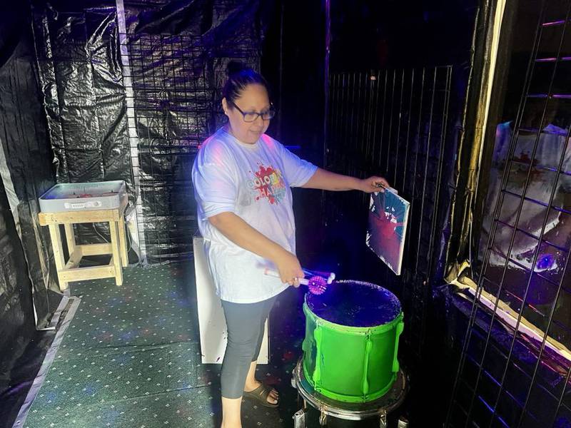 Sonia Robinson bangs a paint drum at her art studio, Color Me Happy, in Sterling, Illinois.