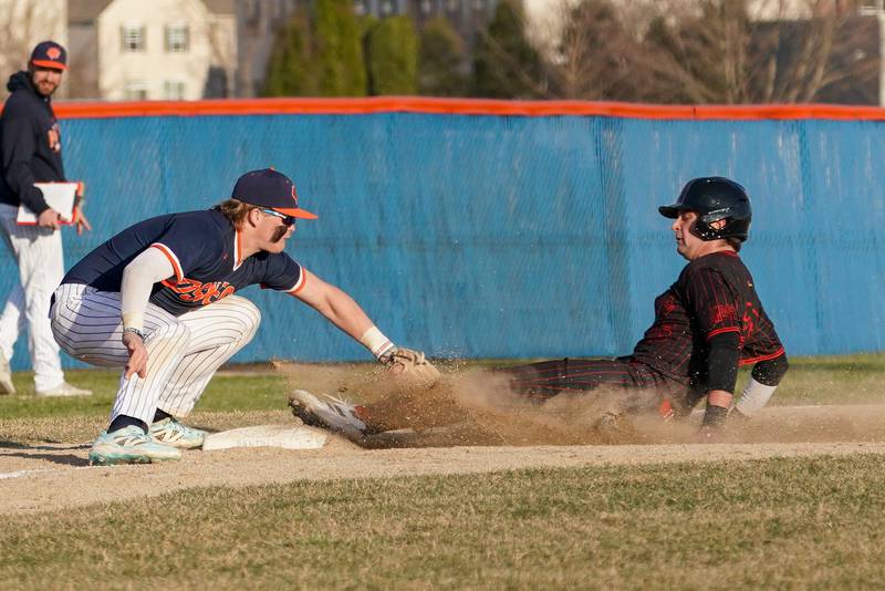 Benet’s Maxwell Glimco (right), beats the tag by Oswego’s Easton Ruby during a baseball game at Oswego High School on Tuesday, March 25, 2025.
