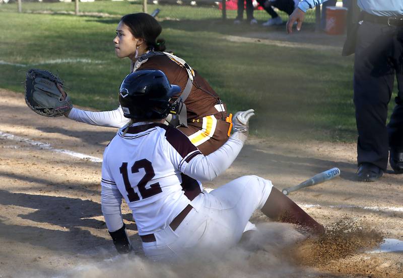 Jacobs' Kate Takasaki waits for the throw as Prairie Ridge’s Bella Moore slides into home for a run during a Fox Valley Conference softball game on April 8, 2026, at Prairie Ridge High School.