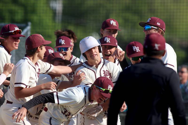 Prairie Ridge’s Tyler Vasey is mobbed by the Wolves after he belted a home run against Woodstock North in Class 3A Regional baseball action at Cary Thursday.