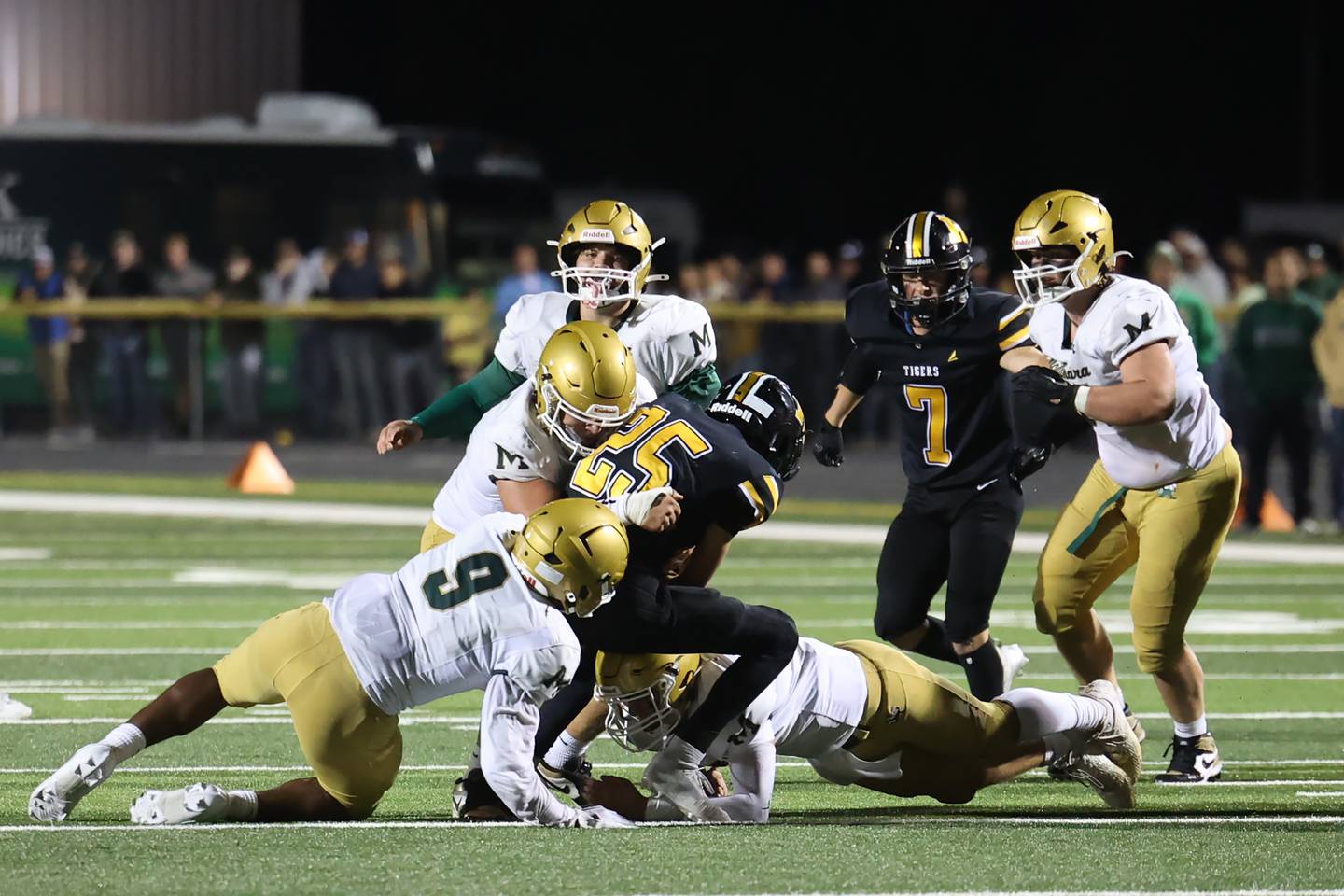 Herscher's Mason Roberts is taken down by a host of Bishop McNamara defenders during the Tigers' 45-28 loss to Bishop McNamara on Friday, Sept. 5, 2025.