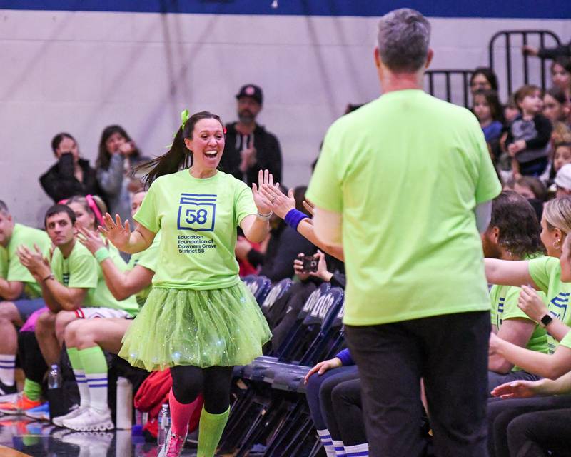 Katelyn Morgan a Downers Grove staff member  gets high five from the Downers Grove staff as he gets introduces at the start of the game on Sunday Jan. 19, 2025, as the staff took on the Harlem Wizards held at Downers Grove South High School.