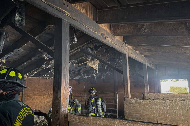 The Woodstock Fire/Rescue District evaluate the damage inside a barn at the 3300 block of Stieg Road near Woodstock after a fire broke out on Dec. 10, 2025.
