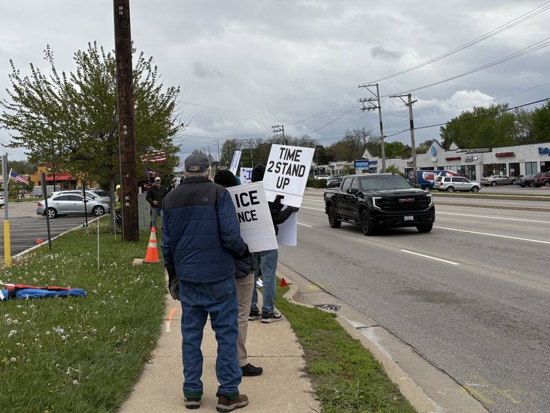 Protestors hold up signs during a May 1 protest in McHenry Friday May 1, 2026.