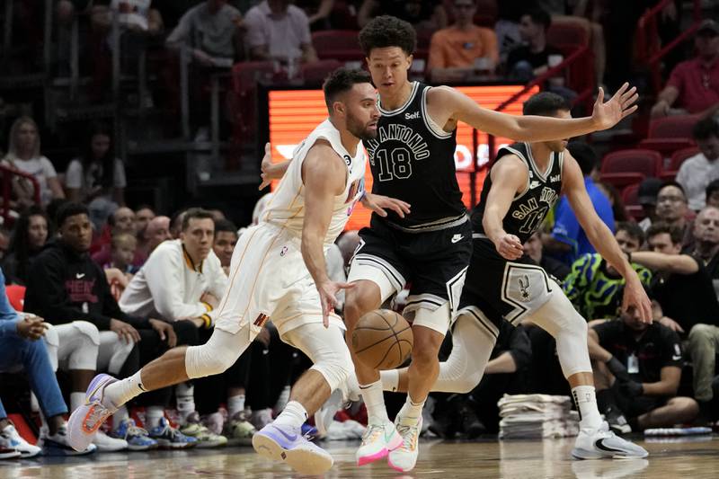 Miami Heat guard Max Strus, left, drives to the basket as San Antonio Spurs forward Isaiah Roby defends during the first half of an NBA basketball game, Saturday, Dec. 10, 2022, in Miami.