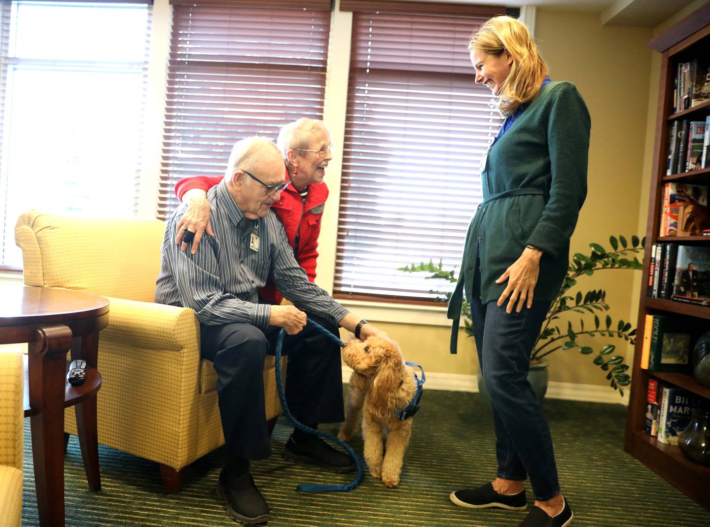 GreenFields of Geneva residents Bob and Judie Knott pet Grizzly Bear as Grizzly Bear’s owner and handler Leslie Paquette looks on. Paquette is the life services manager at the senior living community and had her 4-year-old mini golden doodle trained to be a therapy dog.