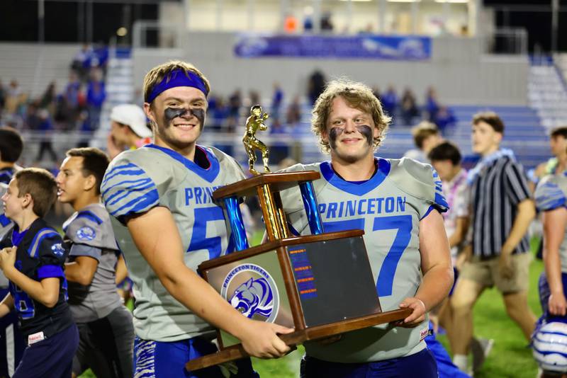 Princeton Tigers hoist the spoils of victory after their 63-12 win over Kewanee on Friday.