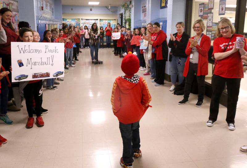 Marshall Morong, (center) 7, a first grader at Hinckley-Big Rock Elementary School, is cheered on as he walks to his classroom Monday, May 5, 2025, after arriving for his first day back at school following months waiting for, and eventually receiving, heart transplant surgery at Lurie Children’s Hospital of Chicago. Morong arrived in style in a Tesla Cybertruck donated for use by Telsa of Naperville, along with an escort by Hinckley and Big Rock first responders.