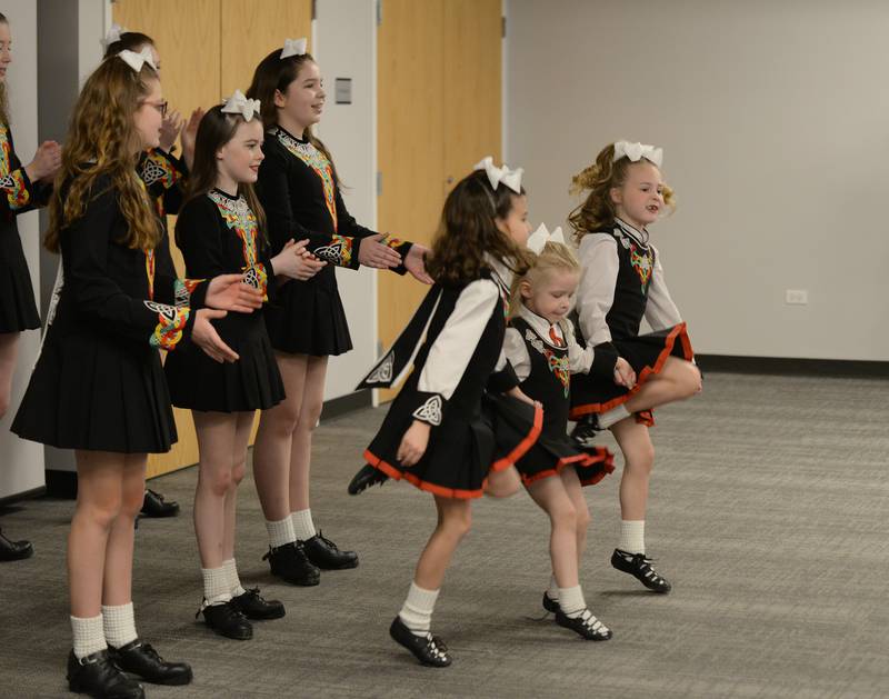 Trinity Irish Dancers (left-right) Zoe Rabbitt, Violett Pyktta, and Emmerson Cotter dance to celebrate St. Patrick's Day at the Downers Grove Library Saturday, March 16, 2024.