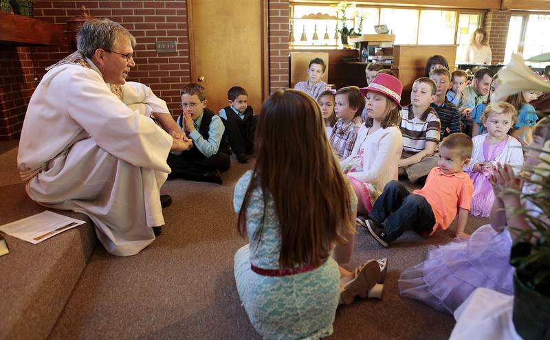 Pastor Greg Lucas gives talks with children during the 2014 Easter Sunday worship service at St. Paul's United Church of Christ in Crystal Lake.