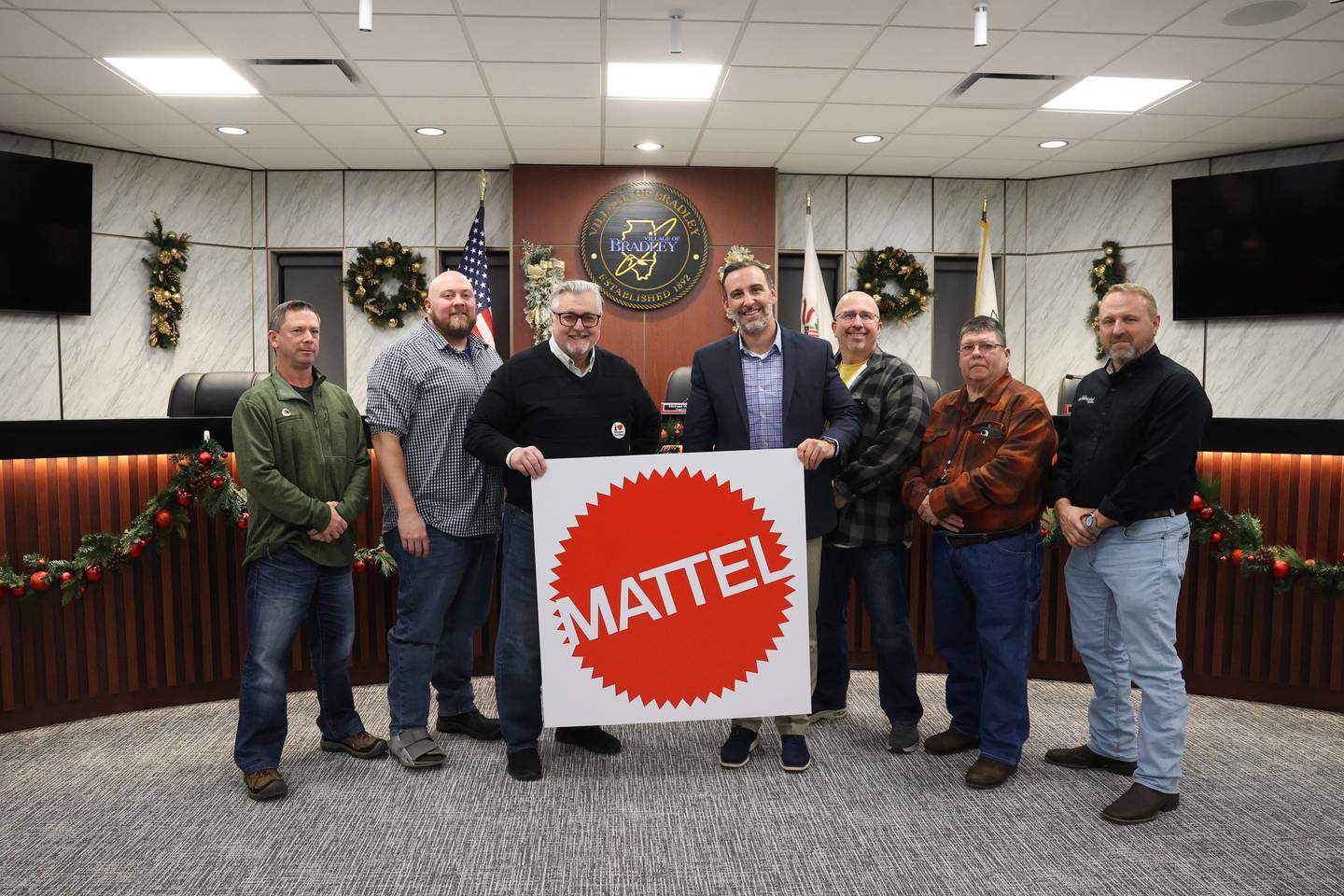Bradley Mayor Mike Watson, left, center, and board members stand with Justin Brown, right center, executive vice president of development with American Resort Management, after the resolution to approve the licensing agreement for the planned waterpark passed at the village Bradley board meeting on Monday, Dec. 8, 2025. American Resort Management and Mattel have partnered to create a new brand of indoor waterparks, Mattel Wonder. Bradley's waterpark wil be one of the first sites.