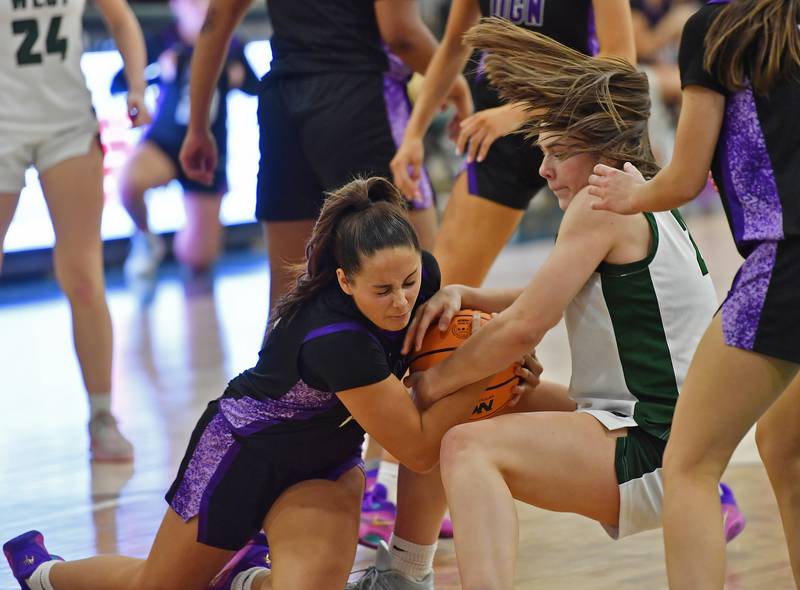 Downers Grove North’s Adysen Fanta (left) and Glenbard West’s Ellie Noble wrestle for the ball during a game on December 4, 2025 at Glenbard West High School in Glen Ellyn.