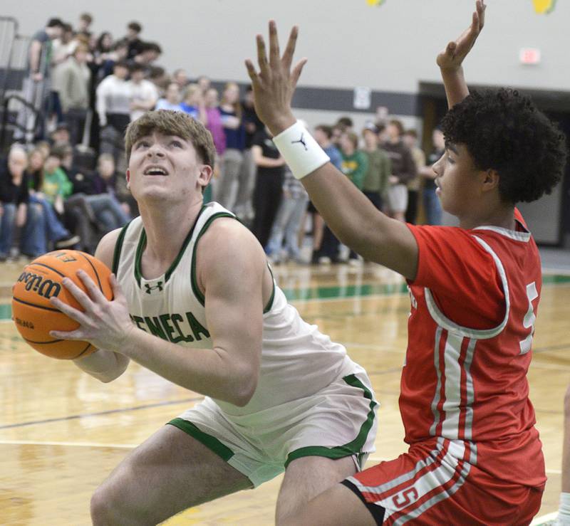 Seneca’s Cam Shirley eyes the basket as Seneca’s Lavontae Horton sets to block in the 2nd period Tuesday at Seneca.