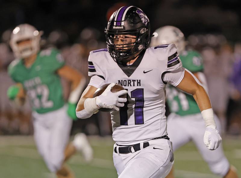 Downers Grove North's Charlie Cruse (11) runs with the ball during the varsity football game between Downers Grove North and York on Friday, Oct. 4, 2024 in Elmhurst.