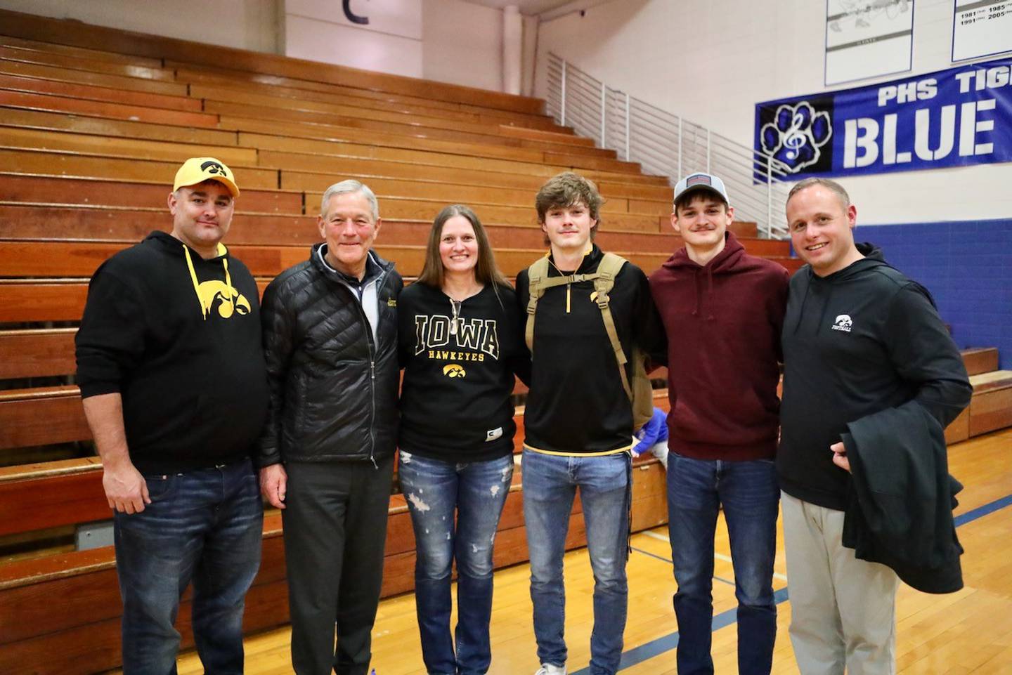 Iowa Hawkeye football coaches Kirk Ferentz and Seth Wallace visit with Princeton's Teegan Davis and family after Tuesday's basketball game at Prouty Gym. Davis has signed to play football for the Hawkeyes this fall. Pictured are Spencer Davis, Ferentz, Annette  Davis, Teegan Davis, Cael Davis and Wallace.