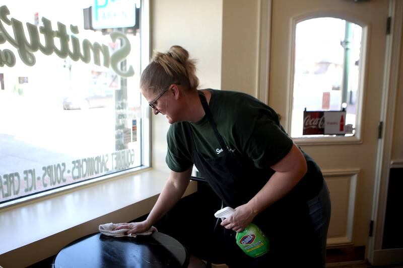Ann Smith wipes down a table at Smitty's on the Corner in St. Charles. In response to the recent coronavirus outbreak, Smith said that in addition to their already diligent cleaning protocols, they have added about a half hour of deep cleaning each day at the popular lunch spot.