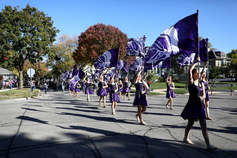 Downers Grove North flag corps members walk on Friday, Oct. 18, 2024 during the school’s annual homecoming parade.