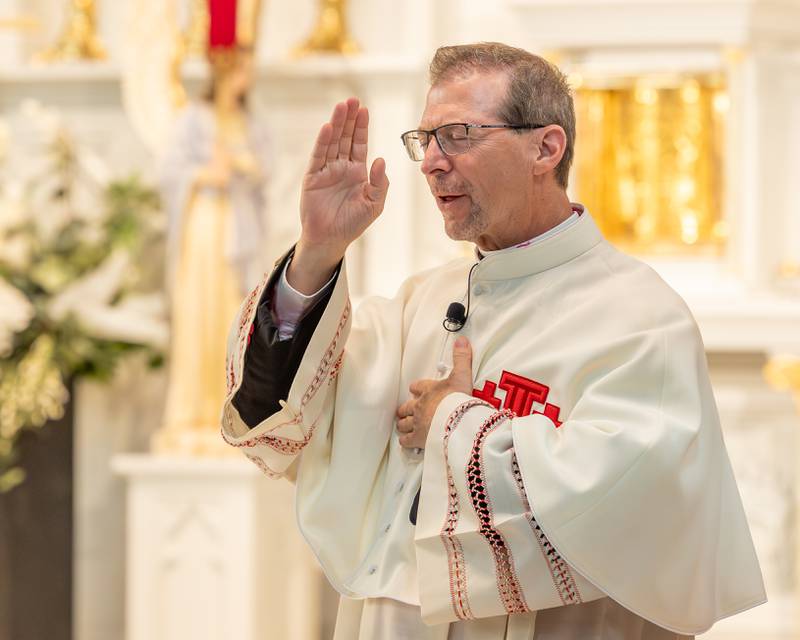 Monsignor Mark Merdian makes the sign of the cross after leading in a prayer at the 2026 Marquette Academy Graduation Ceremony on May 24, 2026 at St. Columba Church in Ottawa.