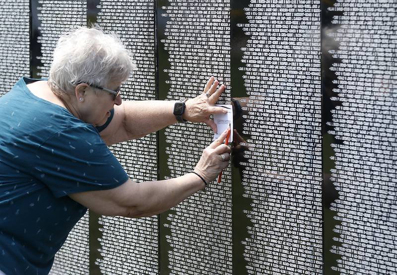 Sharon Klauser makes a rubbing of her cousin, Charles W. Lower’s name, as she visits the Vietnam Traveling Memorial Wall at the VFW Post 4600 in McHenry, on Friday, July 14, 2023. Her cousin, who served in the U.S. Army died in Vietnam in November of 1969.  The 3/5 scale wall Will be at the post and open to the public until Sunday evening and will hold an opening ceremony at 10 a.m. on Saturday.