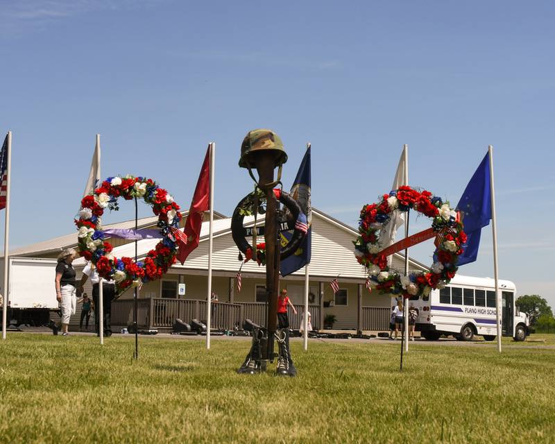Military flags, wreaths and a monument stand to honor fallen service members at the Little Rock Township Cemetery during the Memorial Day remembrance ceremony on Monday, May, 29, 2023.