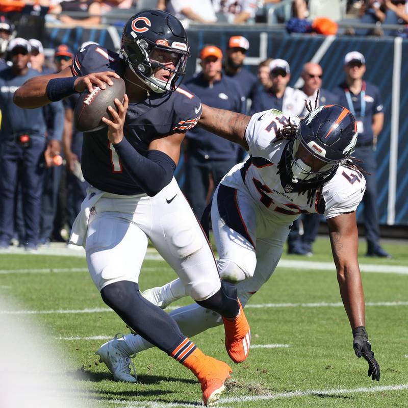 Chicago Bears quarterback Justin Fields scrambles away from Denver Broncos linebacker Nik Bonitto to throw a touchdown pass during their game Sunday, Oct. 1, 2023, at Soldier Field in Chicago.