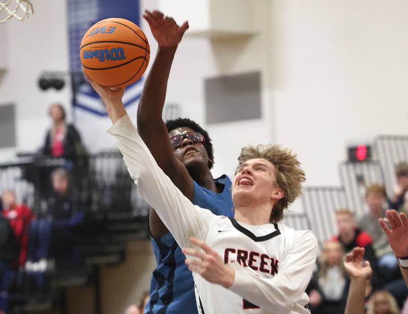 Indian Creek's Parker Murray shots under IMSA’s Lota Onwuameze Friday, Feb. 6, 2026, during their Little 10 Conference championship game at Somonauk High School.