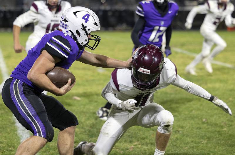 Dixon’s Landon Knigge stiff arms Marengo’s Alten Bergbreiter Friday, Nov. 1, 2024 in the 4A football playoffs in Dixon.