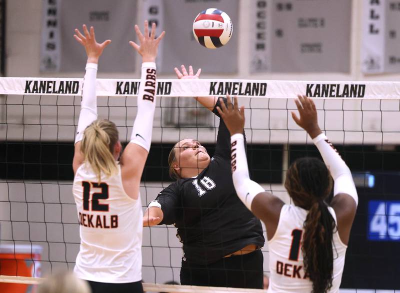 Kaneland's Leah Shirley spikes the ball between DeKalb's Isabelle Smith (left) and Jordan Grant Thursday, Sept. 4, 2025, during their match at Kaneland High School in Maple Park.