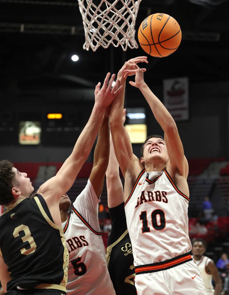 DeKalb's Jack Rosenow and Sycamore's Marcus Johnson go after a rebound Friday, Jan. 30, 2026, during the FNBO Challenge at the Convocation Center at Northern Illinois University in DeKalb.