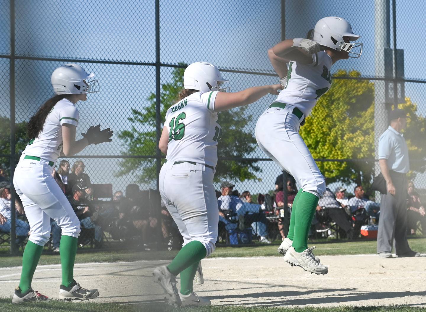 Rock Falls' Olivia Osborne leaps with excitement after she and Brooke Howard (left) scored Friday during the Class 2A Stillman Valley Sectional championship game. On-deck hitter Zoe Morgan also celebrates.