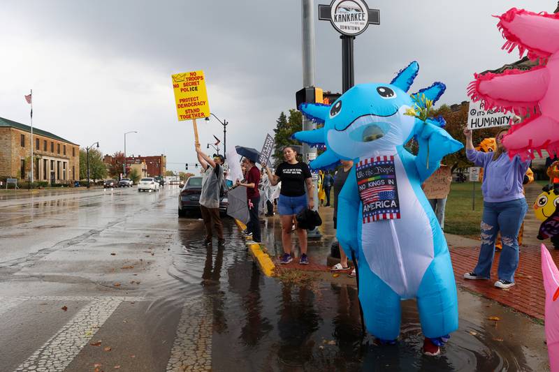 Protestors continue demonstrating after heavy rains at the Kankakee County Courthouse during the No Kings Rally on Saturday, Oct. 18, 2025.