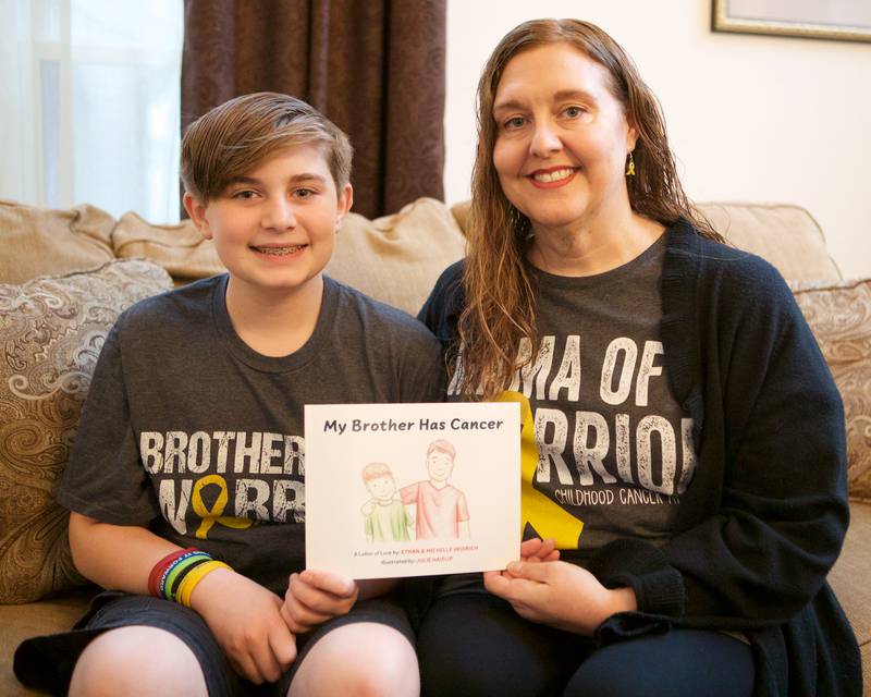 Co Authors Ethan and Michelle Heidrich pose with the book they wrote together "My Brother has Cancer" on Saturday, April 29,2023.